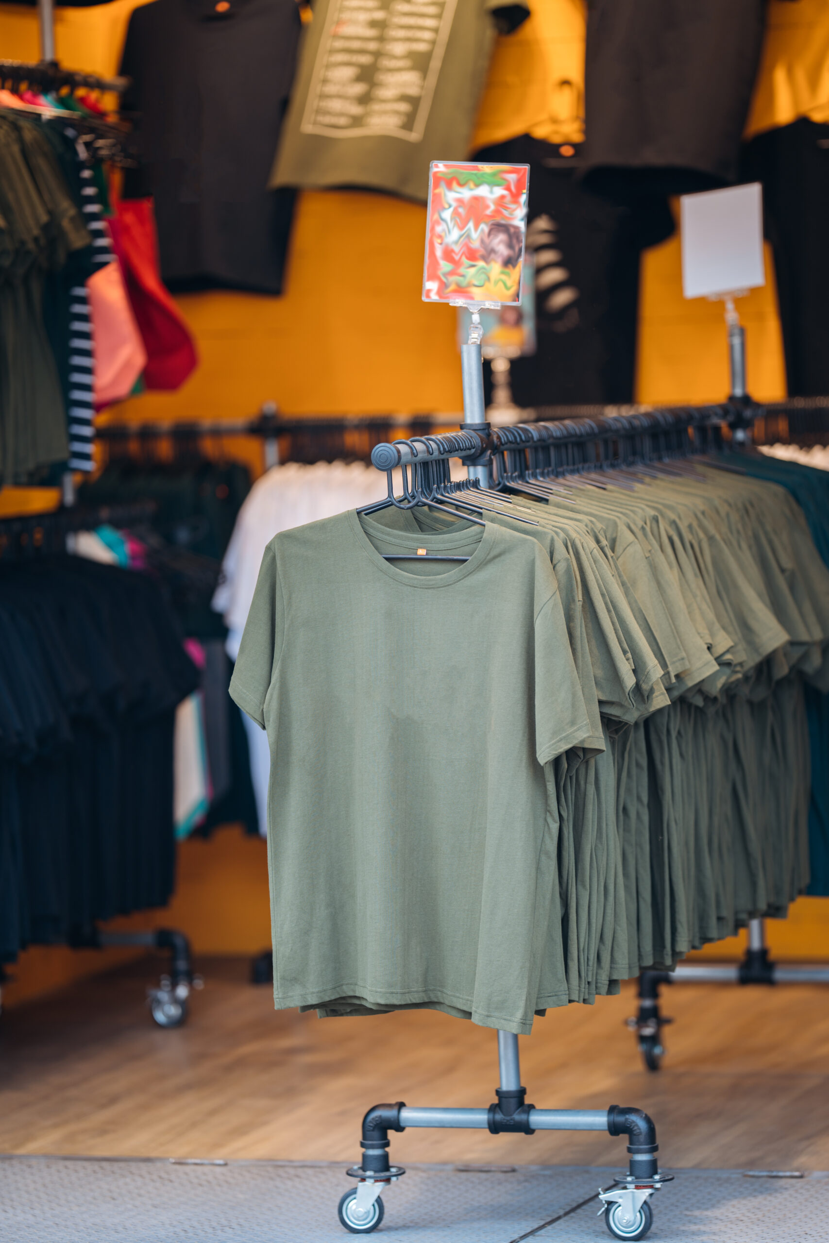 Minimalist T-Shirt Display. Simple and stylish green t-shirts displayed in a minimalist fashion store.